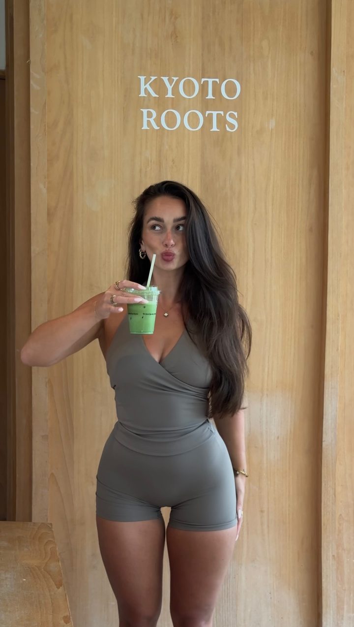 Laura in a grey activewear set holding an iced matcha