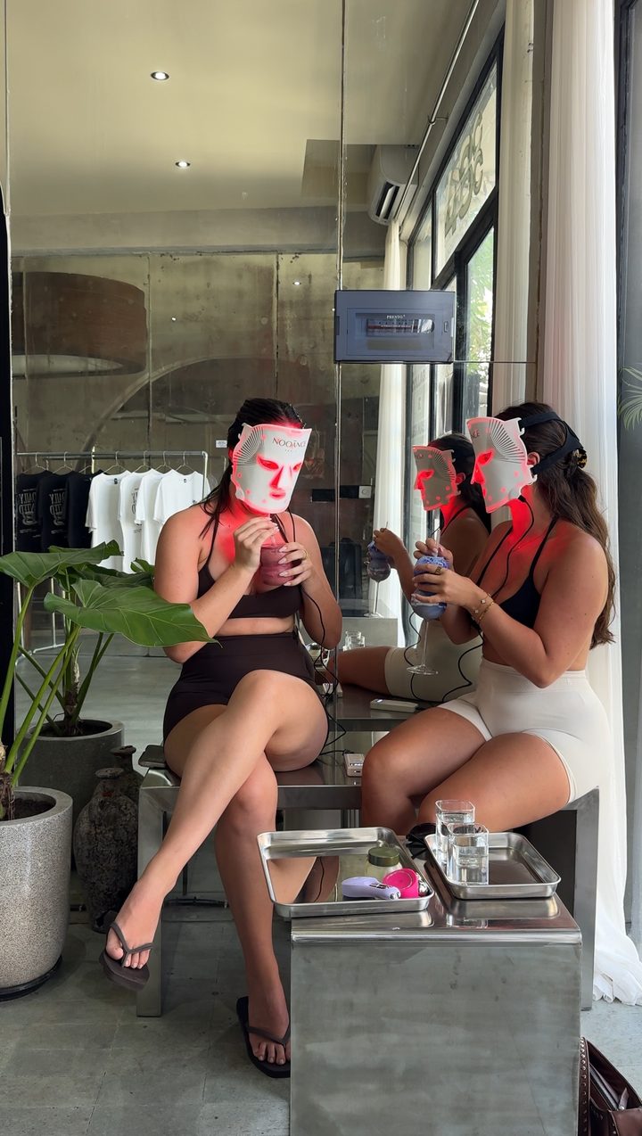 Two women wearing LED face masks at a collagen cafe